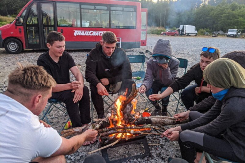 The group siting round the campfire after a day of riding at Nevis Range